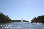 A sail in the narrow part of Barösund, seen from the water.